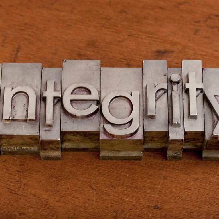 integrity word in vintage, metal letterpress printing blocks on scratched wooden background